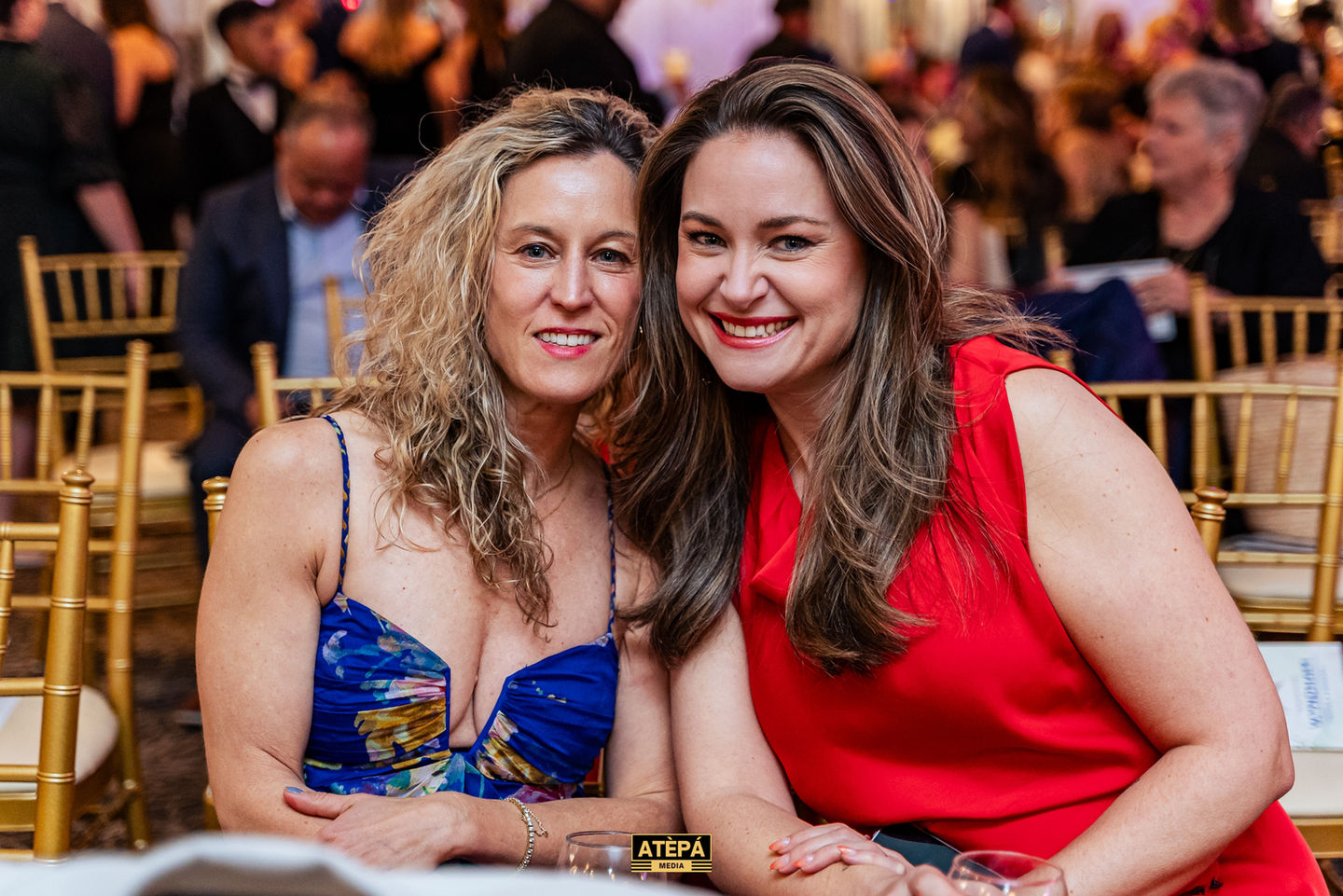Two people smiling at an event.