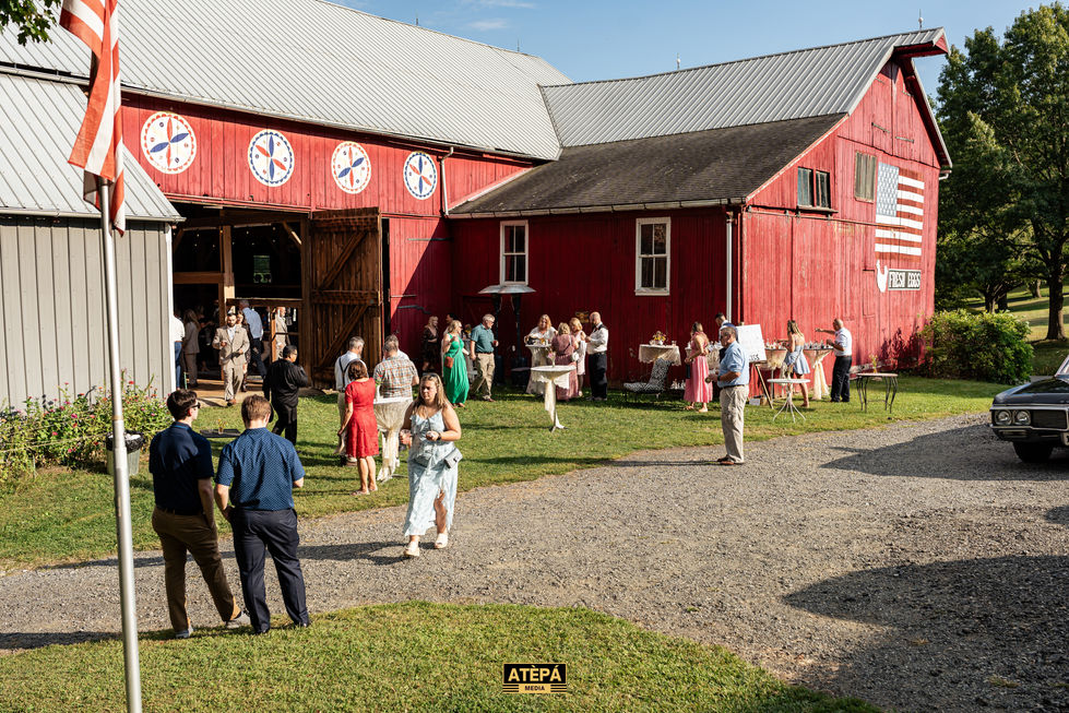 People gathered outside a large red barn.