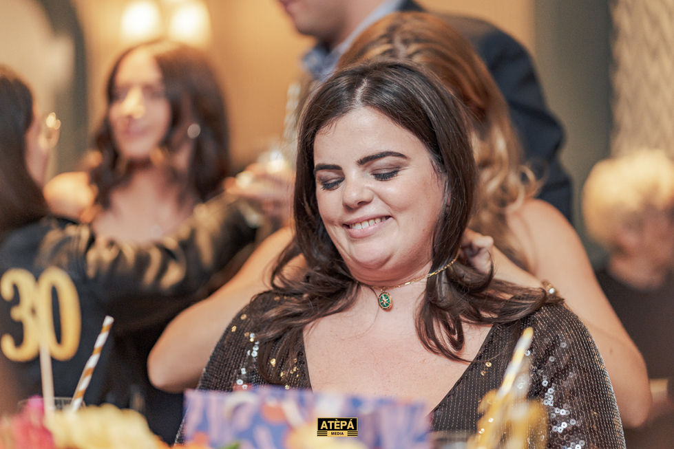 a woman is smiling in front of a sign that says atepa