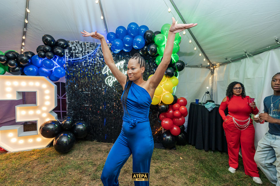 a woman is dancing in front of balloons and a sign that says atepa