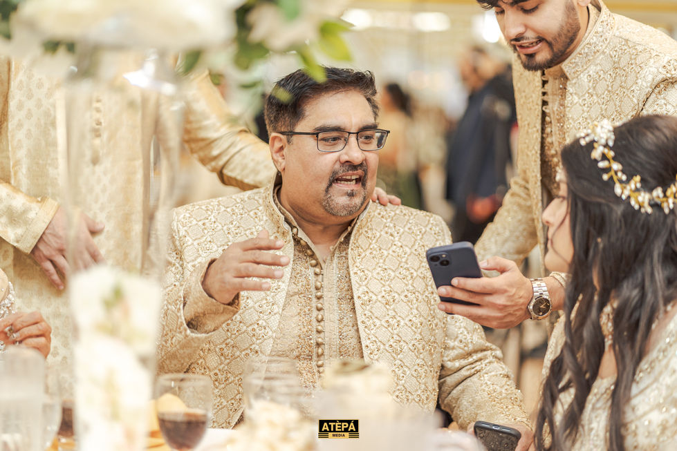 a man in a gold suit is looking at a cell phone