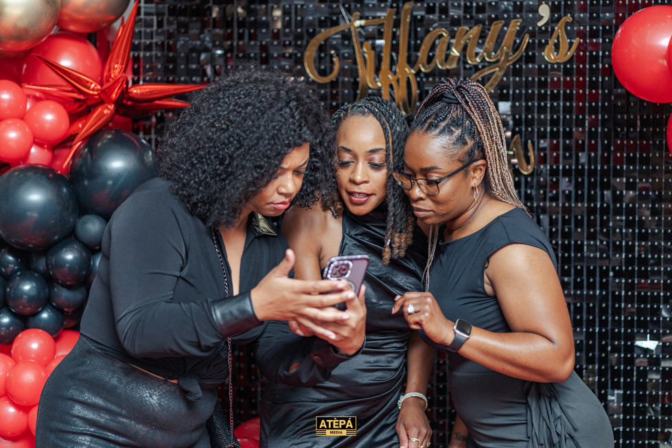 three women looking at a cell phone with the word atepa on the bottom