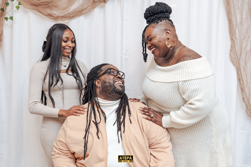 a man with dreadlocks is surrounded by two women and the word atepa is on the bottom of the photo