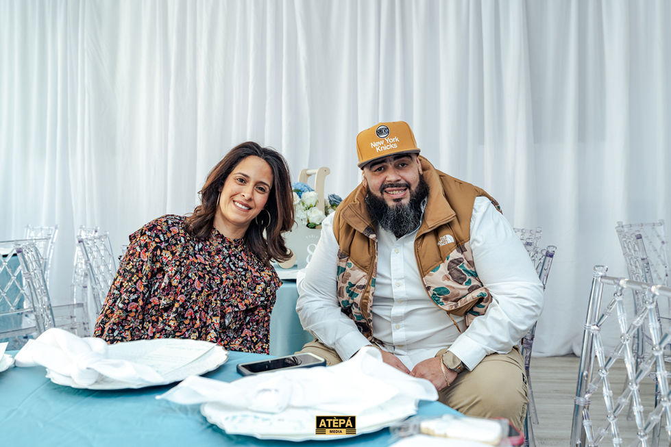 a man wearing a hat that says new york yachts sits next to a woman
