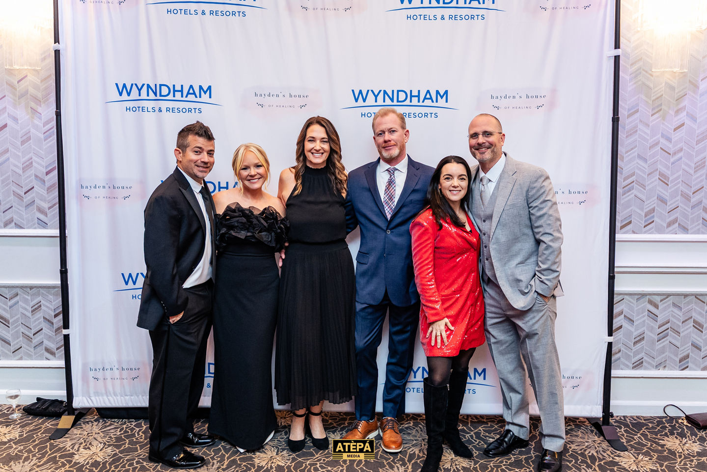 Group of people posing at an event backdrop.