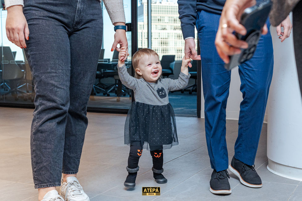 a little girl wearing a black dress with a cat on it