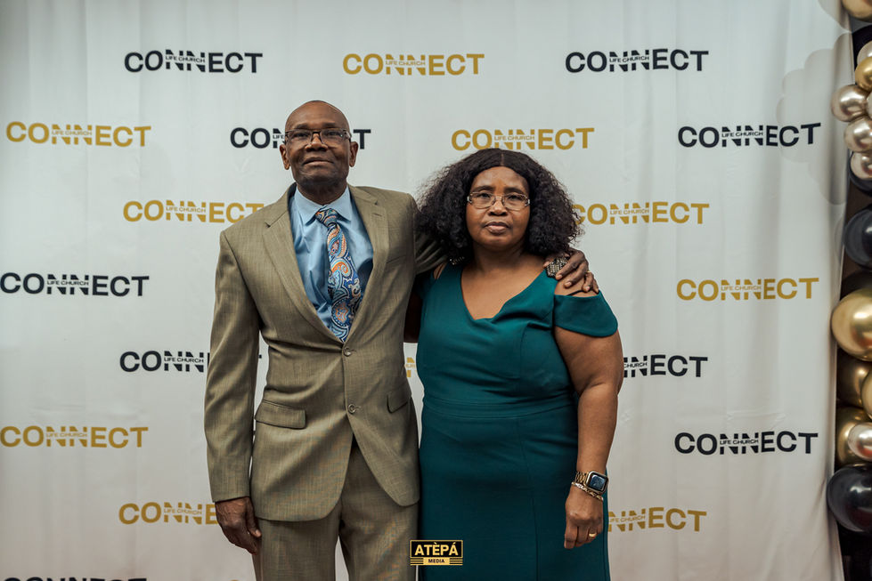 a man and woman pose in front of a wall that says connect