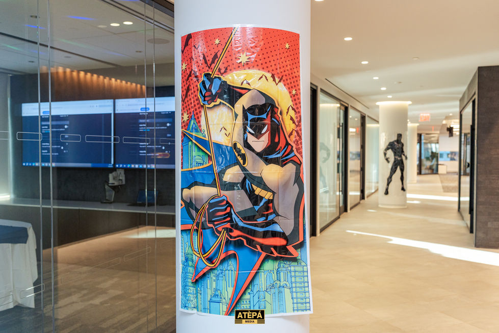 a poster of batman is hanging on a white pole