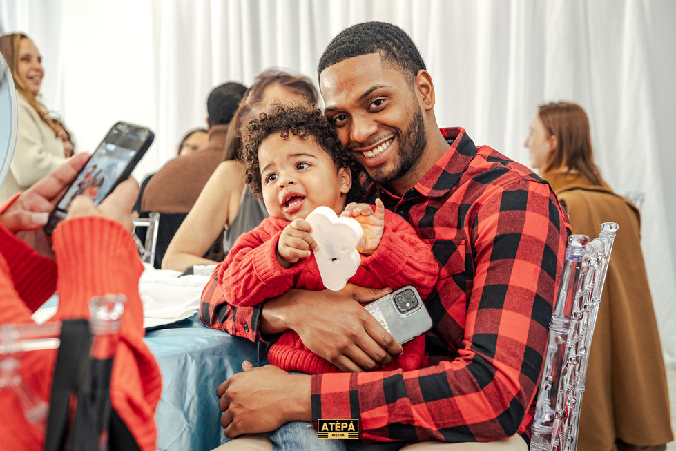 a man in a plaid shirt is holding a baby