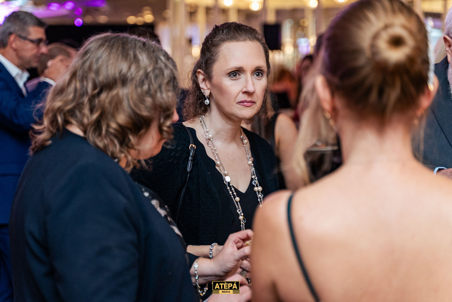 People conversing at a formal event or gathering.