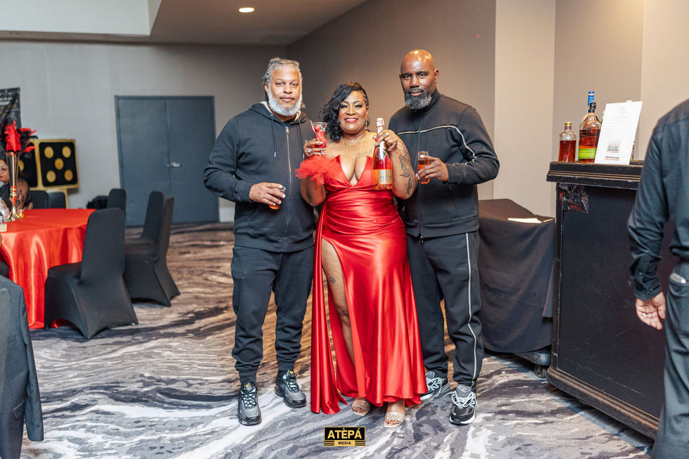 a woman in a red dress stands between two men and a sign that says atepa