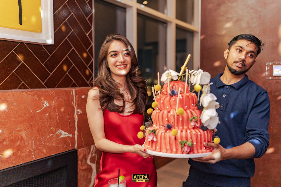 a woman in a red dress is holding a cake that says atepa on it