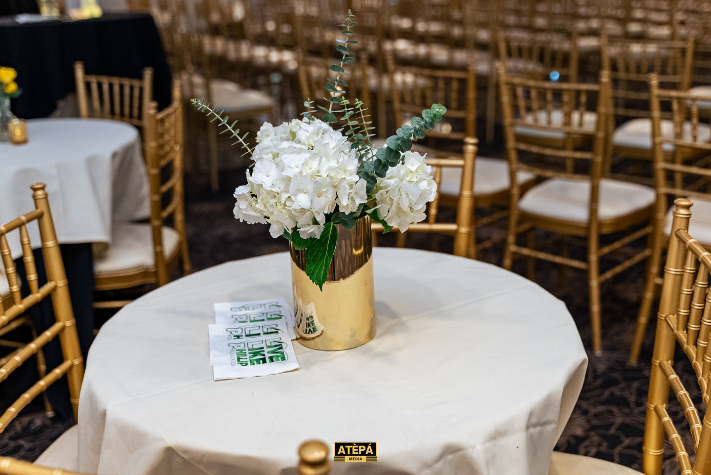 Elegant table setting with white flowers and gold accents.