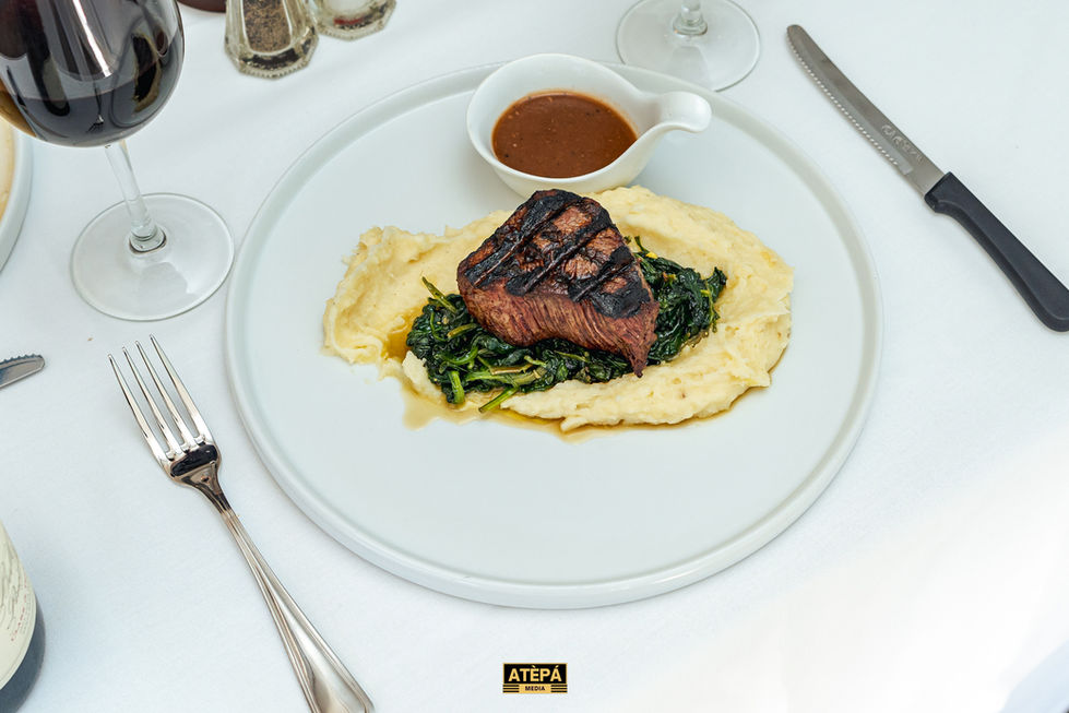 a white plate with a steak on top of mashed potatoes