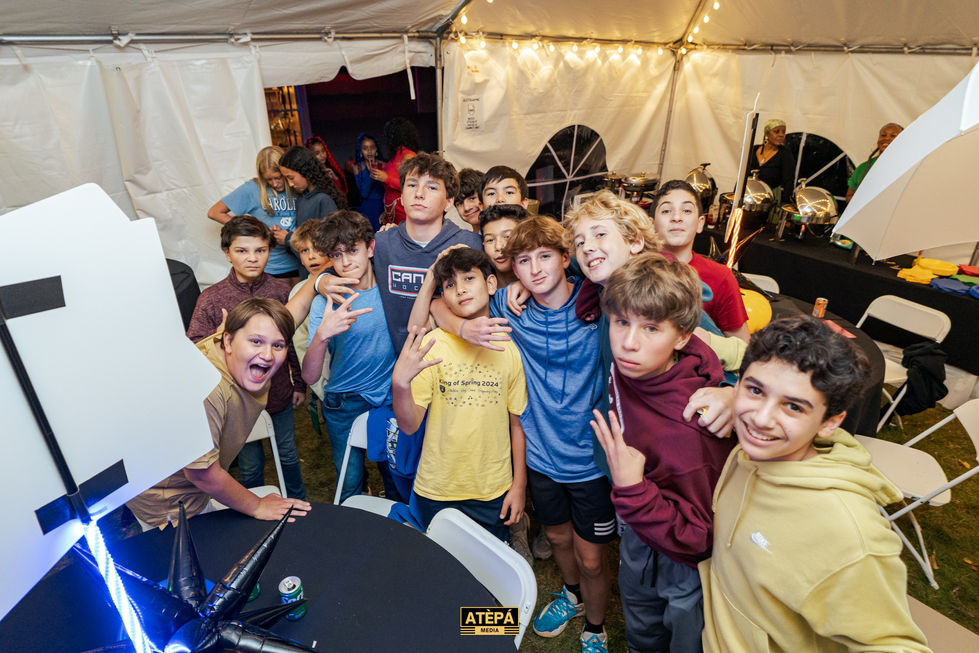 a group of young boys posing for a photo in front of a tent that says atepa