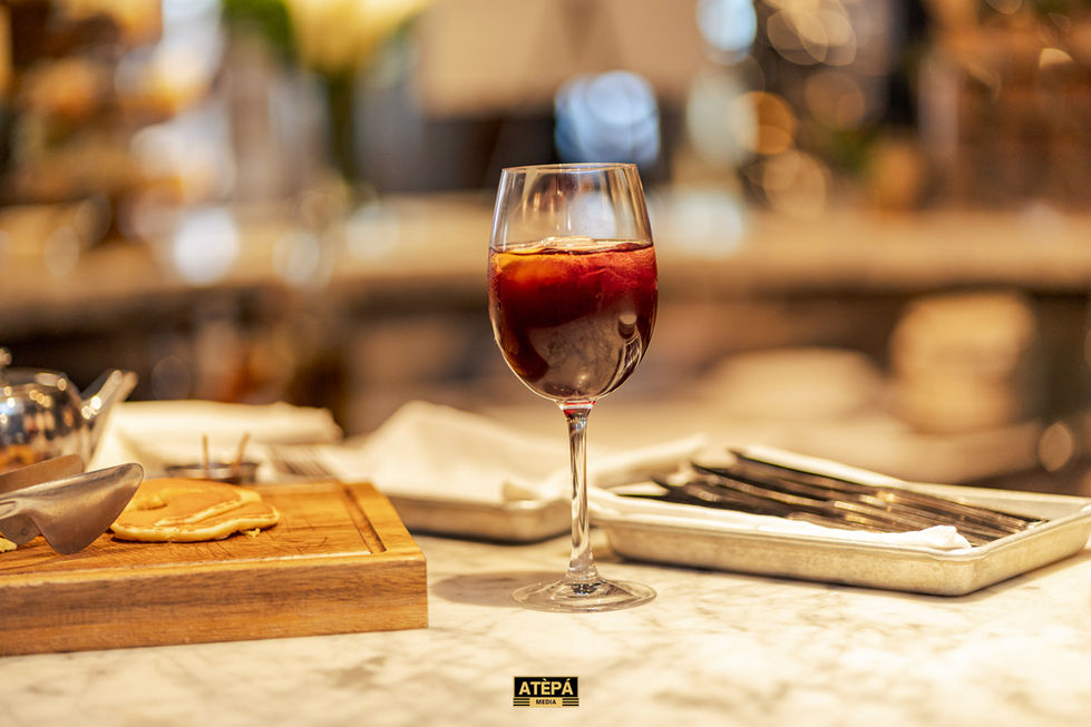 a glass of wine sits on a table next to a sign that says atepa