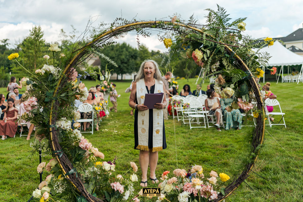 Woman standing in floral circle at outdoor event.