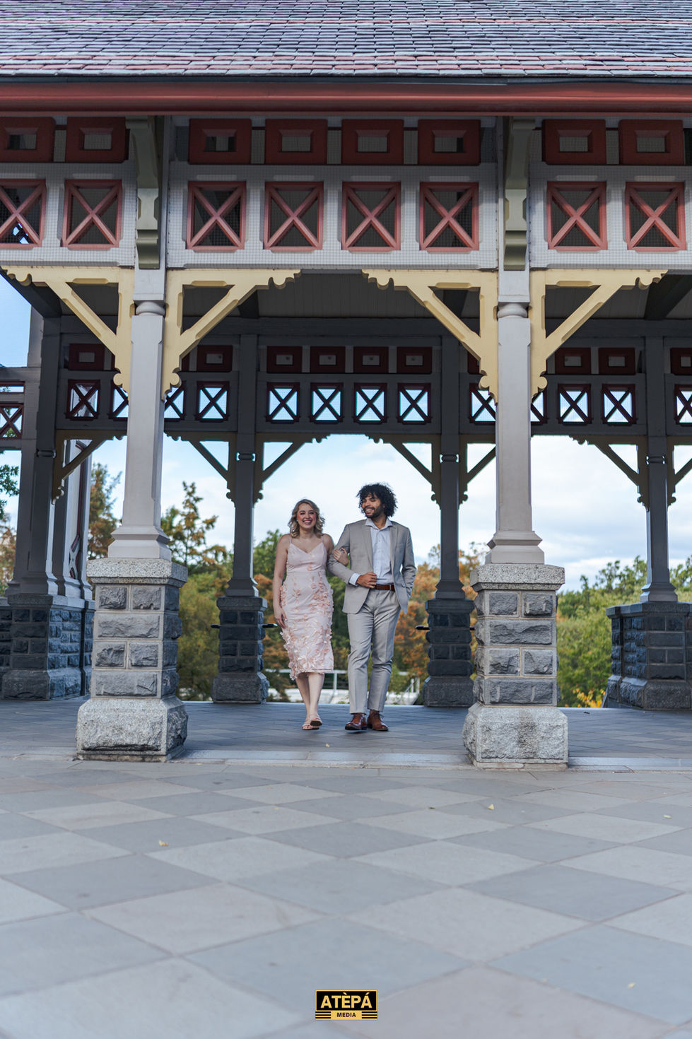 a man and a woman are walking under a gazebo