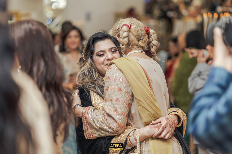 a woman hugging another woman with the word atepa on the bottom