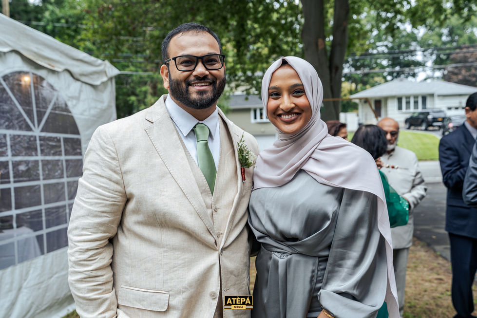 a man and woman are posing for a picture and the man is wearing glasses