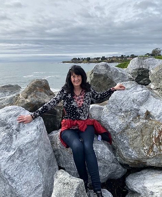 Susan sitting on the rocks overlooking ocean in California