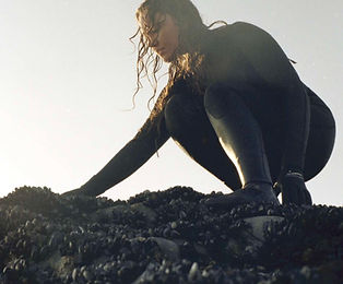 woman in wetsuit near rockpool