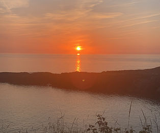 sunset over cliff and calm water