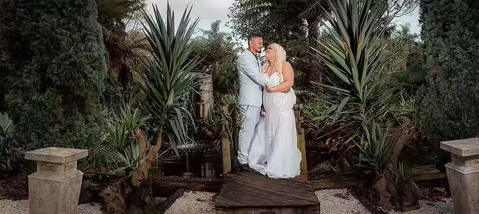 Bride and groom by the lake at Markovina Estate, sharing a romantic moment during their Auckland wedding.
