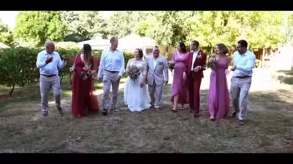 Christchurch wedding videography at The Vines Club: The entire wedding party walking together in a sunny garden