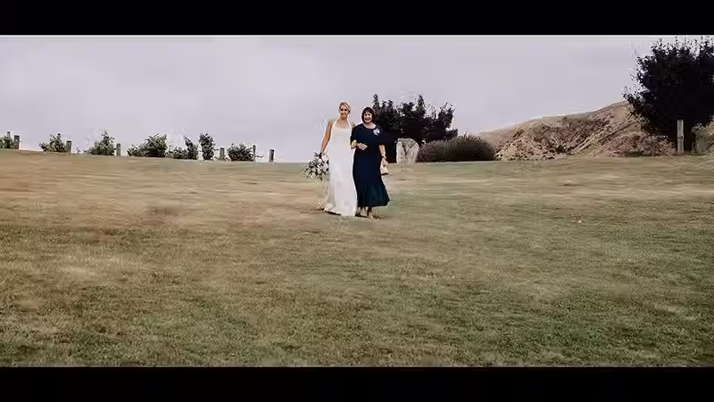 Wanaka Wedding Videography: Bride and her mother walking across a grassy field at The Rippon Hall.