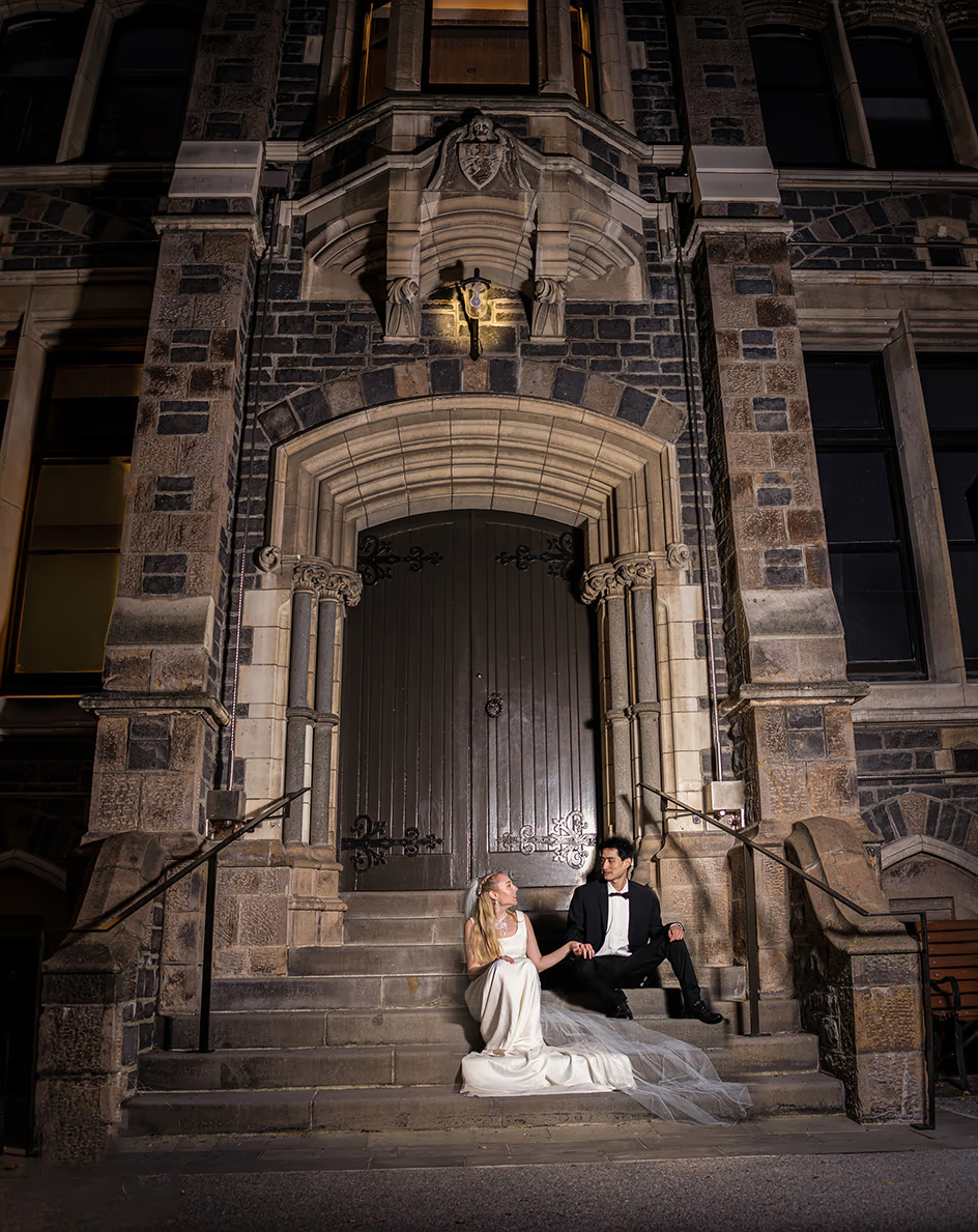 Couple sharing a romantic moment sitting on the grand staircase inside the Christchurch Arts Centre, ideal for urban wedding photography.