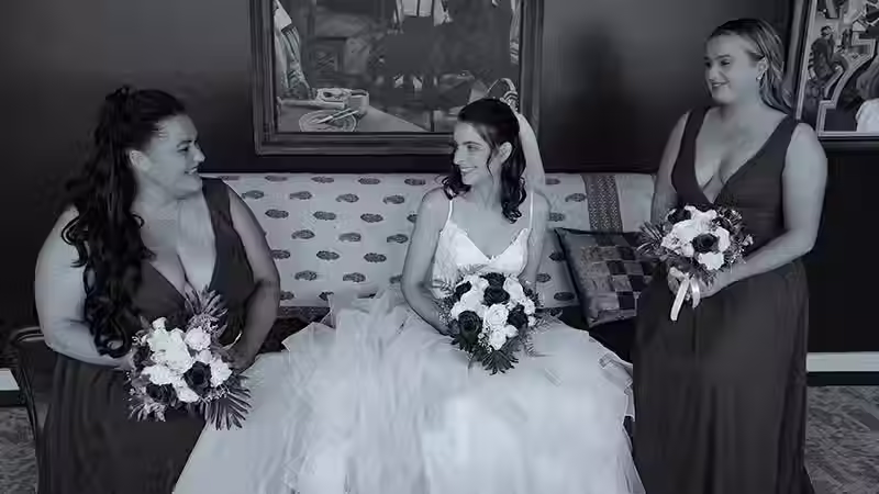 Christchurch wedding photographer and Hanmer Springs: Black and white photo of bride and bridesmaids smiling together on a couch.