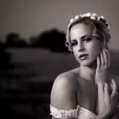 Fine art black and white wedding photography featuring a close-up bridal portrait of a bride wearing a flower crown at Godley Head in Christchurch.