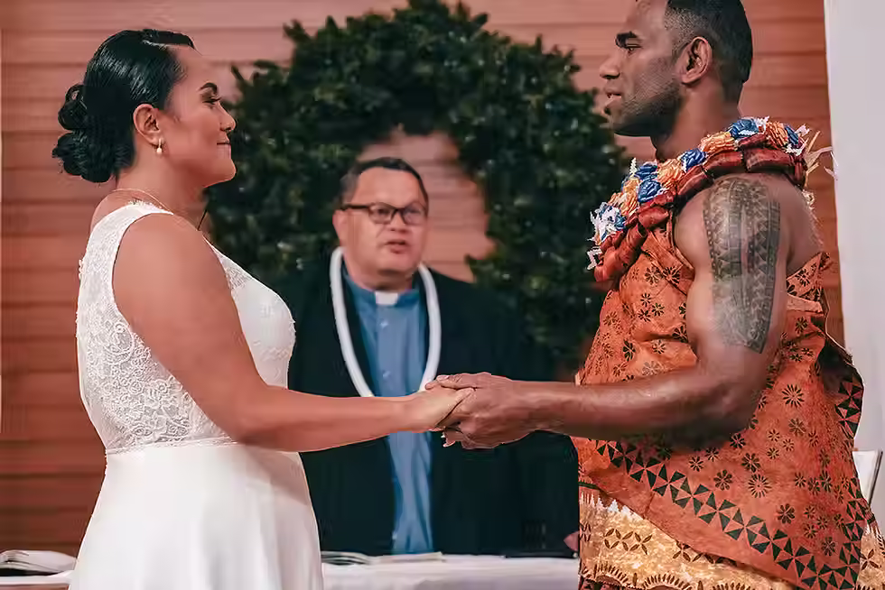 Lincoln wedding photographer: Grace and Atunaisa exchanging vows at the altar, a romantic moment at their Lincoln Wedding Venue, Lincoln Event Centre.