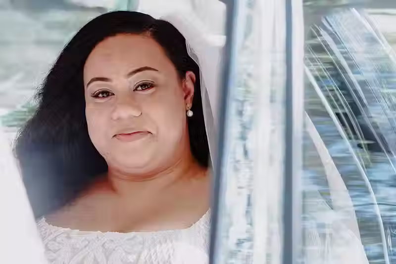 Bangor Farm wedding: bride looking calmly from inside a car, wearing her wedding dress and veil, a thoughtful moment in Christchurch.
