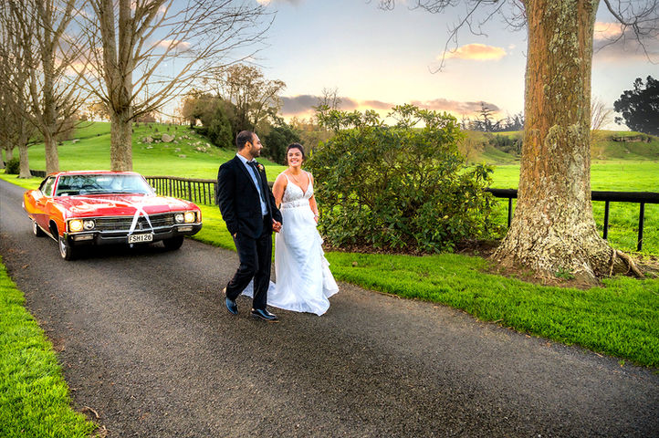 Couple walking happily hand-in-hand at Red Barn, Hamilton, captured by Christchurch wedding photographer Kiwi Moments Media, experts in NZ wedding photography and videography.