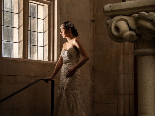 Bride in a white wedding dress gazing out of a window inside a historic castle, captured by professional wedding photographer Kiwi Moments Media in Christchurch, New Zealand.