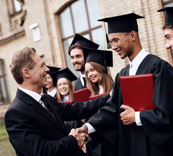 The teacher gives the students diplomas in the courtyard of the university. They finish th