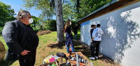 Miran13.7 zeigt Workshop-Schülern Graffiti-Techniken, daneben beobachtet Cornelius Rinne (Beuys-Schüler) die Arbeit am Aldegrever-Gymnasium.