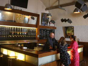 2 women standing at a bar.