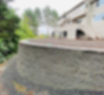 large grey concrete block retaining wall on a steep backyard slope, structural landscaping in Issaquah, WA.