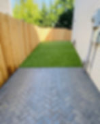 herringbone pattern grey pavers next to a new green lawn and wooden fence, installed by Guzman construction, LLC. in Everett , wa