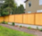 grey block retaining wall with wooden privacy fence on top in a residential backyard, Guzman construction, Llc.