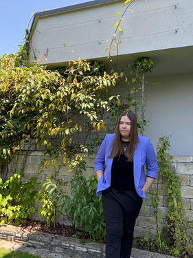 Karoline Aberger vor einem blühenden Strauch. 
