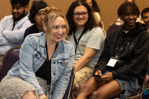 Multi racial group sitting in chairs smiling