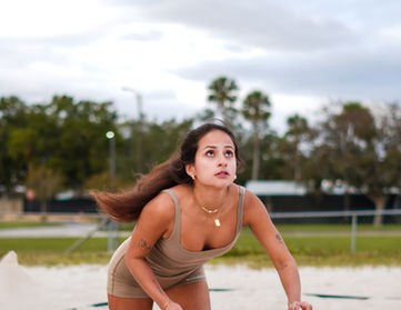 Woman stretching outdoors wearing Aesthetics Dynasty brown performance set, athletic movement