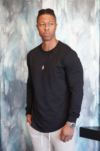 Man in the Aesthetics Dynasty Venture Long Sleeve in Noir Élégant, fitted black cotton long sleeve with curved hem