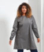 a woman wearing the grey all purpose gown. She has curly hair.