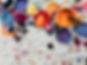 Colourful cans of paint and brushes on a messy canvas drop sheet