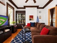 Living room from the far end showing sectional sofa, desk nook, and French doors